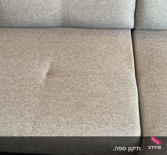 כרית ריפוד אפורה על ספה עם תפרים